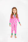A young girl with long hair is smiling against a plain white background, wearing The Beaufort Bonnet Company’s Sara Jane’s Sweet Dream Set - Bows of Holly with Kiawah Kelly Green, a pink holiday family matching pajama set.