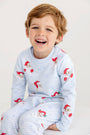 A smiling young boy wearing the Cassidy Comfy Crewneck - Dear Santa (Buckhead Blue Stripe) with Buckhead Blue pajamas in a light blue and white striped print decorated with a repeating Santa Claus pattern.