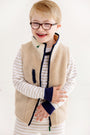 A young boy with glasses and Down syndrome smiles, wearing The Beaufort Bonnet Company’s Cassidy & Gates Sweat Set in Keeneland Khaki Stripe & Nantucket Navy, styled for fall loungewear against a white background.