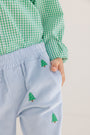 A child wearing a green checkered shirt and The Beaufort Bonnet Company’s Critter Sheffield Pants in Buckhead Blue Corduroy with embroidered Christmas Trees puts one hand in their pocket.