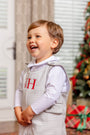 A smiling toddler wears a Jack Keene Jon Jon - Grantley Gray Houndstooth with Grantley Gray over a white collared shirt, featuring the monogram TWH embroidered in red, perfect for a winter family portrait.
