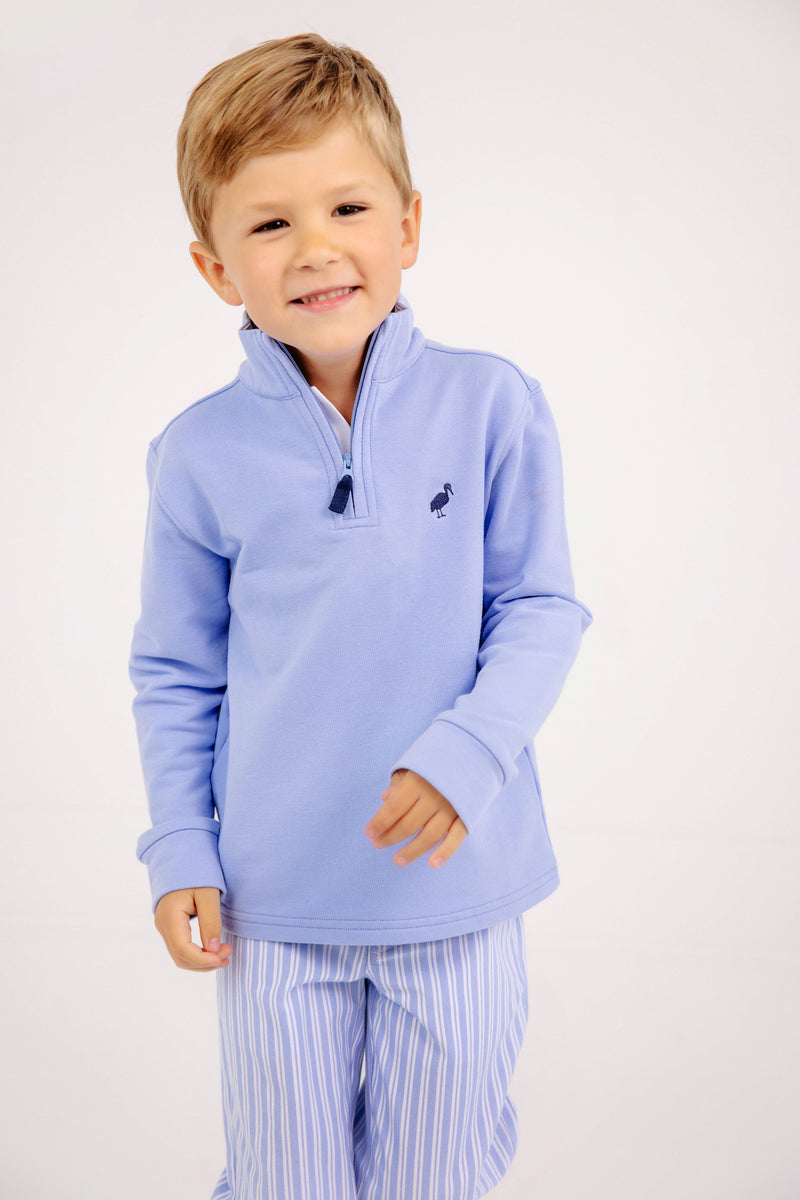 A young boy wearing a Hayword Half Zip - Park City Periwinkle with Nantucket Navy Stork pullover and light blue striped pants made of a soft Cotton Spandex blend.