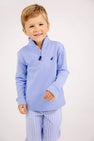 A young boy wearing a Hayword Half Zip - Park City Periwinkle with Nantucket Navy Stork pullover and light blue striped pants made of a soft Cotton Spandex blend.