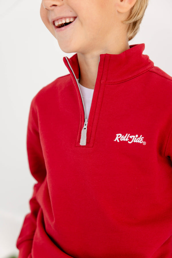 A child wears The Beaufort Bonnet Company’s Alabama Hayword Half-Zip in Alabama Crimson with Alabama Grey and Worth Avenue White, featuring “Roll Tide” embroidered in white on the chest. With only the lower part of their face and upper body visible, this cozy half-zip is perfect for game day layering.