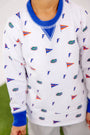 A child stands on green grass wearing The Beaufort Bonnet Company’s Florida Cassidy Comfy Crewneck – Florida Forever with Florida Blue, a white sweatshirt featuring blue collar and cuffs, accented with small University “F” logos and orange pennants.