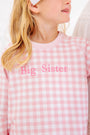 A child wears a Cassidy Comfy Crewneck - Palm Beach Pink Gingham with Hamptons Hot Pink Big Sister, a pink and white gingham sweatshirt embroidered with hot pink lettering for a sibling reveal outfit.