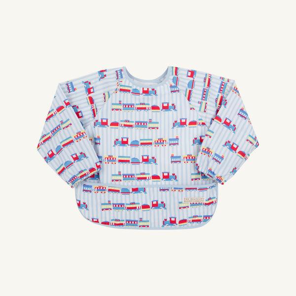 The Beaufort Bonnet Company’s Biscuit Bib - Choo Choo Coming Through with Buckhead Blue features a vibrant train motif and the playful phrase “Choo Choo Coming Through” on a light blue and white striped background, perfect for young children.
