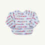 The Beaufort Bonnet Company’s Biscuit Bib - Choo Choo Coming Through with Buckhead Blue features a vibrant train motif and the playful phrase “Choo Choo Coming Through” on a light blue and white striped background, perfect for young children.
