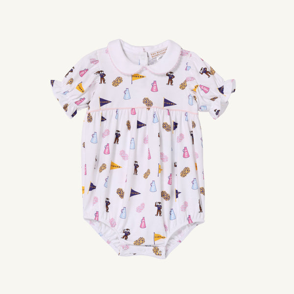 The LSU Britt Bubble - Tenacious Tigers with Palm Beach Pink by The Beaufort Bonnet Company is a white baby romper with a peter pan collar and puff sleeves, featuring the Tenacious Tigers print adorned with printed megaphones, pom-poms, bears, and uniforms in pastel pink, blue, yellow, and brown. Crafted from soft Pima Cotton for ultimate comfort.