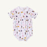 The LSU Britt Bubble - Tenacious Tigers with Palm Beach Pink by The Beaufort Bonnet Company is a white baby romper with a peter pan collar and puff sleeves, featuring the Tenacious Tigers print adorned with printed megaphones, pom-poms, bears, and uniforms in pastel pink, blue, yellow, and brown. Crafted from soft Pima Cotton for ultimate comfort.