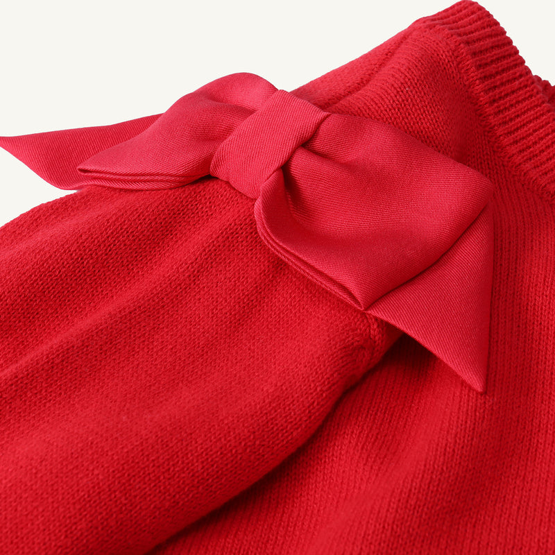 Close-up of The Beaufort Bonnet Company’s Cambridge Cardigan in Richmond Red with Bows, featuring a large matching red fabric bow near the collar. The detailed knit texture and smooth fabric of the bow are clearly visible.