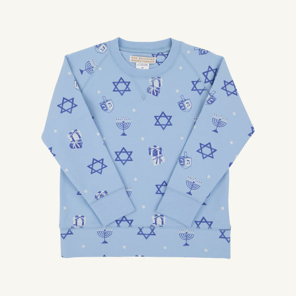 Introducing the Cassidy Comfy Crewneck - Eight Nights to Remember with Barbados Blue by The Beaufort Bonnet Company: a light blue, ultra-comfy kids’ sweatshirt adorned with playful blue Stars of David, dreidels, menorahs, and small white snowflakes. Displayed on a plain white background, this Hanukkah sweater is the perfect holiday choice for children.