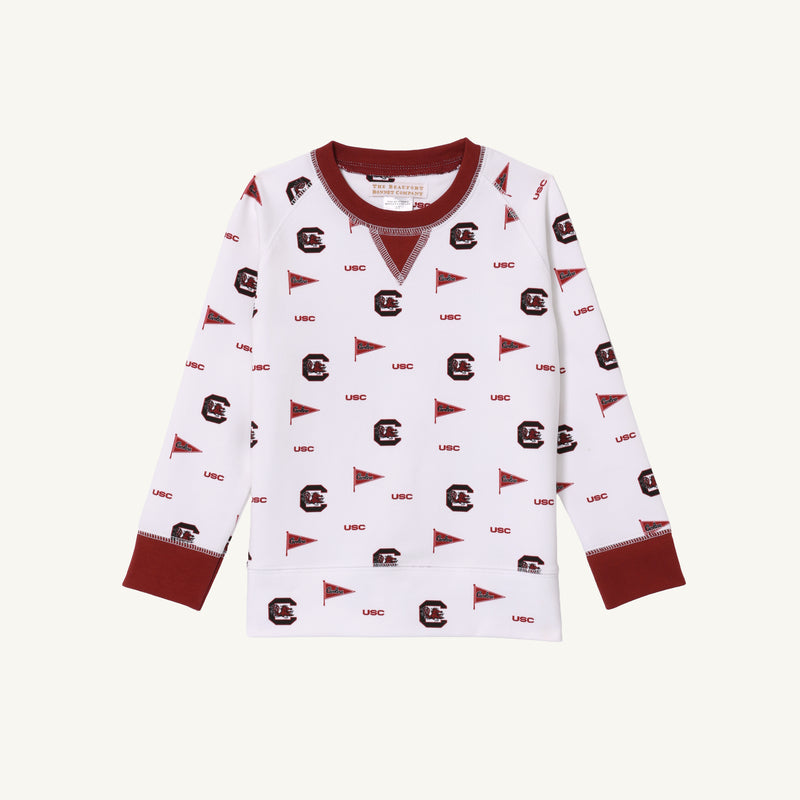 The Beaufort Bonnet Company’s USC Cassidy Comfy Crewneck – South Carolina Spirit with South Carolina Garnet features a white base with maroon (garnet) cuffs and collar. The shirt showcases an evenly spaced pattern of repeating maroon logos, “USC” letters, and pennants inspired by South Carolina Spirit.