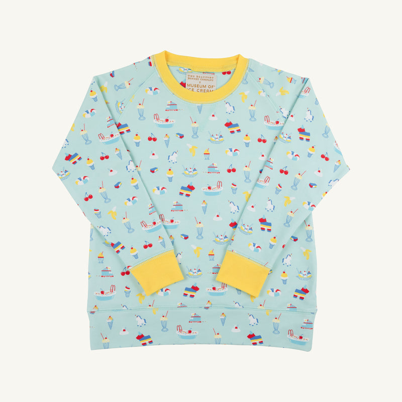 The Beaufort Bonnet Company’s Cassidy Comfy Crewneck - Ice Cream Daydream (Blueberry Blue) is a light blue, long-sleeve kids sweatshirt accented with cheerful yellow cuffs and collar. Featuring playful prints of boats, ice cream cones, cups, cherries, and clouds, this premium crewneck is the perfect fun layering piece for any season.