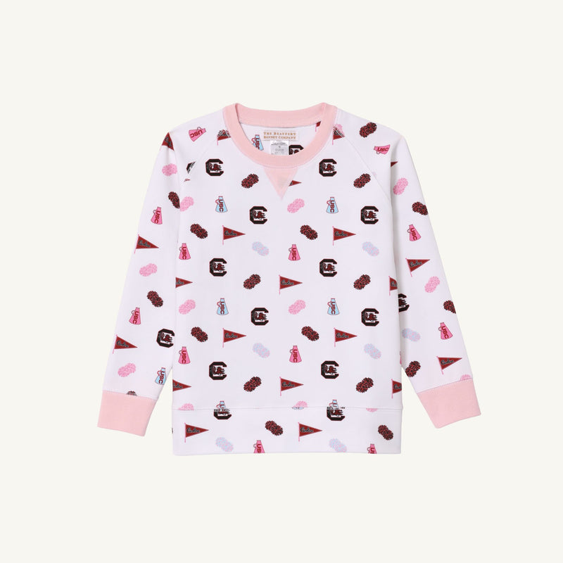 Introducing the USC Cassidy Comfy Crewneck - South Carolina Spirit with Palm Beach Pink by The Beaufort Bonnet Company: a white long-sleeve sweatshirt accented with pink cuffs and collar, decorated in a scattered pattern of small maroon and pink icons—including pennants, letters, dresses, clouds, and ships. This gameday-ready sweater is perfect for showing off your South Carolina spirit!.