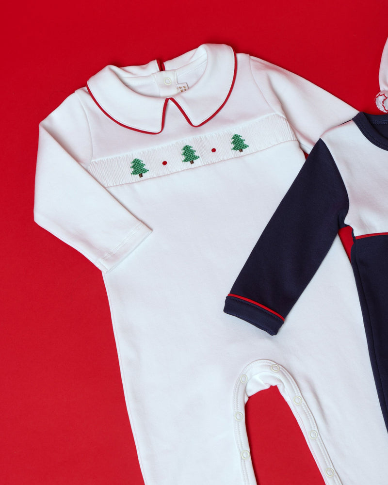 Samuel Smocked Romper - Worth Avenue White & Richmond Red with Trees: a white Pima cotton infant romper with a red-trimmed collar and a smocked chest panel featuring a row of small green embroidered trees.