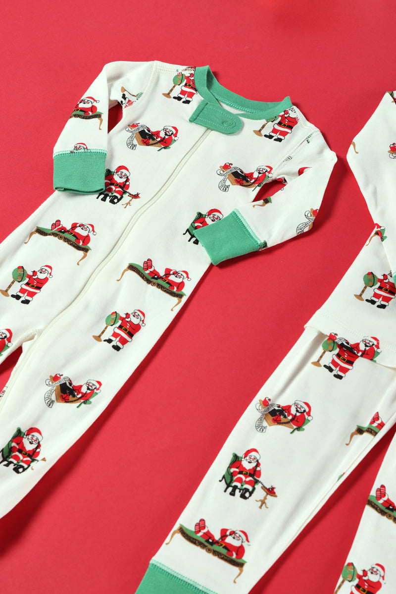Two white “Knox’s Night Night - Serious Santa Business” baby pajamas by The Beaufort Bonnet Company, featuring green cuffs and a playful print of Santa Claus in various poses, are laid flat on a red background. Only part of the second onesie is visible. Crafted from cozy Pima Cotton for ultimate comfort.