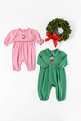 The Beaufort Bonnet Company’s Long Sleeve Ramona Ruffle Romper in Hamptons Hot Pink with Wreath Embroidery, made from soft Pima Cotton, is arranged alongside a green holiday wreath with a red bow on a white background—making the perfect festive outfit for your little one.