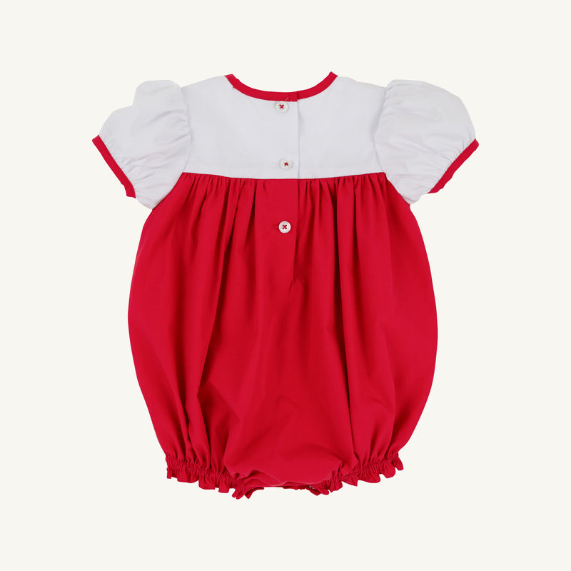 Dress your little one in festive style with the Cindy Lou Bubble by The Beaufort Bonnet Company. This holiday baby outfit features puff sleeves, a white Worth Avenue White top with a charming Christmas Tree detail, and a bright Richmond Red bottom. It’s designed with three buttons down the back, red trim on the sleeves, and elasticized leg openings for a comfortable fit—perfect for celebrating the season!.