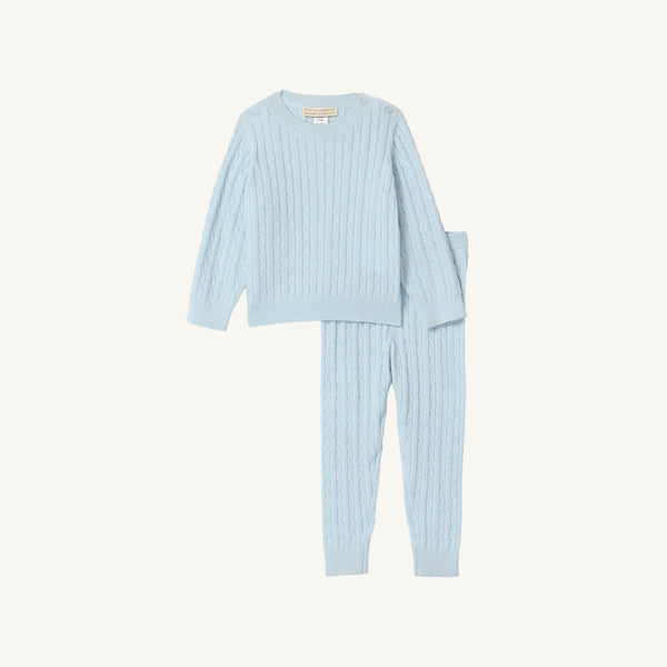 The Crawford Cable Knit Set - Buckhead Blue by The Beaufort Bonnet Company features a light blue, long-sleeve cable knit top with matching pants for children. Crafted from soft cotton, this cozy set is perfect for holiday outfits and is displayed on a plain white background.