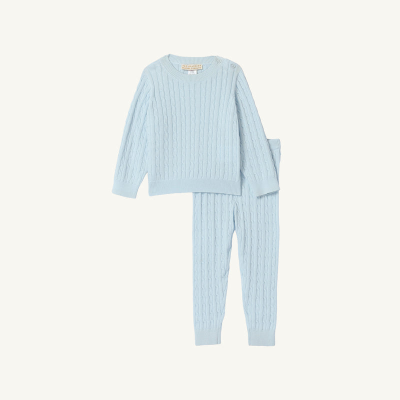 The Crawford Cable Knit Set - Buckhead Blue by The Beaufort Bonnet Company features a light blue, long-sleeve cable knit top with matching pants for children. Crafted from soft cotton, this cozy set is perfect for holiday outfits and is displayed on a plain white background.