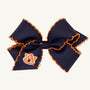 Introducing the Wee Ones Hair Bow - Auburn University by The Beaufort Bonnet Company. This navy blue hair bow features striking orange stitching along the edges and showcases the iconic Auburn University AU logo in orange and white on the left ribbon. Ideal as a Game Day accessory or collegiate hair clip for displaying your school spirit.