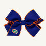 Show your school spirit with The Beaufort Bonnet Company’s Wee Ones Hair Bow - University of Florida. This blue hair bow features vibrant orange edging and an embroidered Gators logo on one ribbon tail, set against a plain background. The Game Day accessory is designed with a secure no-slip hair clip to ensure it stays comfortably in place.
