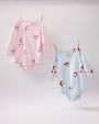 Two Long Sleeve Penny’s Play Bubble - Dear Santa (Palm Beach Pink Stripe) baby rompers with a Santa Claus and snowflake print hanging from a clothesline, one in pink stripes and one in blue stripes.