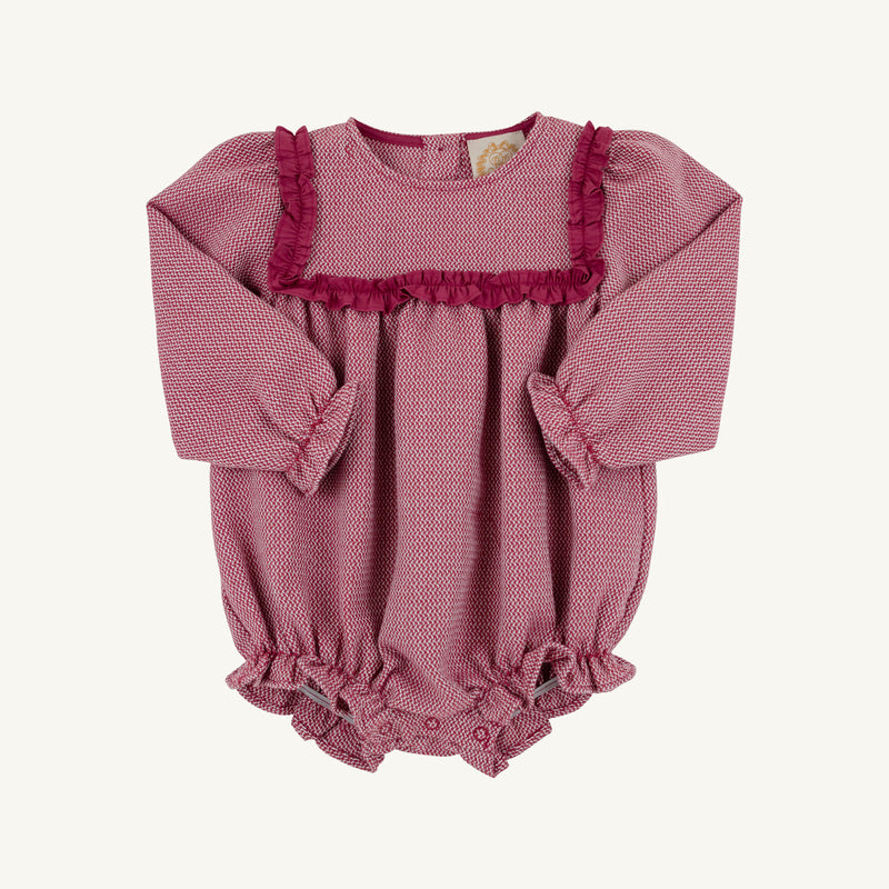 The Debbie Day Bubble in Begley Berry Tweed by The Beaufort Bonnet Company features a charming pink patterned fabric with ruffled trim on the chest and leg openings, plus convenient bottom snaps for easy diaper changes—an adorable baby girl outfit perfect for autumn.