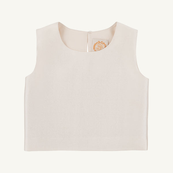The Grandccasion™ Tessa Top by The Beaufort Bonnet Company is a sleeveless, cropped taffeta top in Grand Isle Ivory. Featuring a round neckline and smooth fabric, it is shown laid flat on a plain background, with a tag bearing a gold design visible near the collar.