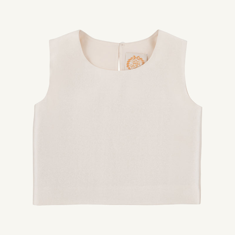 The Grandccasion™ Tessa Top by The Beaufort Bonnet Company is a sleeveless, cropped taffeta top in Grand Isle Ivory. Featuring a round neckline and smooth fabric, it is shown laid flat on a plain background, with a tag bearing a gold design visible near the collar.