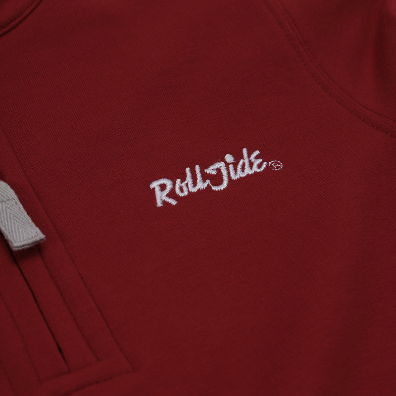 A close-up of The Beaufort Bonnet Company Alabama Hayword Half-Zip in Alabama Crimson with Alabama Grey and Worth Avenue White, featuring “Roll Tide” embroidered in white thread and a gray drawstring visible on the left—perfect for game day layering.
