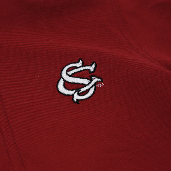 A close-up of The Beaufort Bonnet Company’s USC Hayword Half-Zip in South Carolina Garnet, showcasing a white interlocking SC logo embroidered in Worth Avenue White.