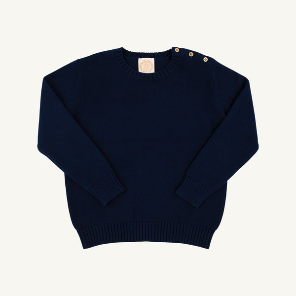 Isabelle’s Sweater in Nantucket Navy is a long-sleeved cotton sweater for girls featuring three brass-colored buttons on the left shoulder.
