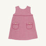 The Beaufort Bonnet Company’s Jill Jumper in Begley Berry Tweed is a sleeveless pink girls’ dress featuring two front pockets, each accented with a button and finished with dark pink trim. The classic, simple design is shown against a plain white background.