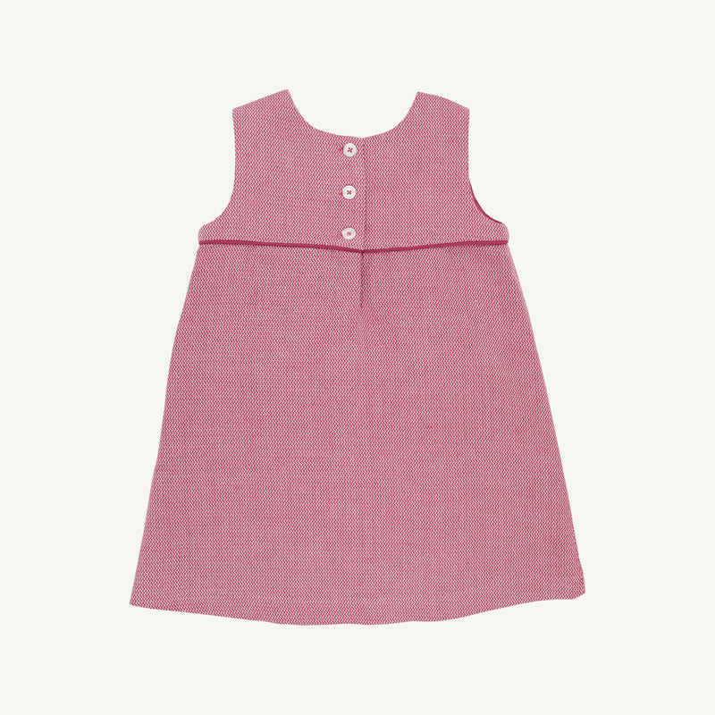 The Jill Jumper - Begley Berry Tweed by The Beaufort Bonnet Company is a sleeveless pink girls jumper dress featuring a textured pattern, an empire waistline, and three white buttons on the back. It is displayed laid flat on a plain white background.