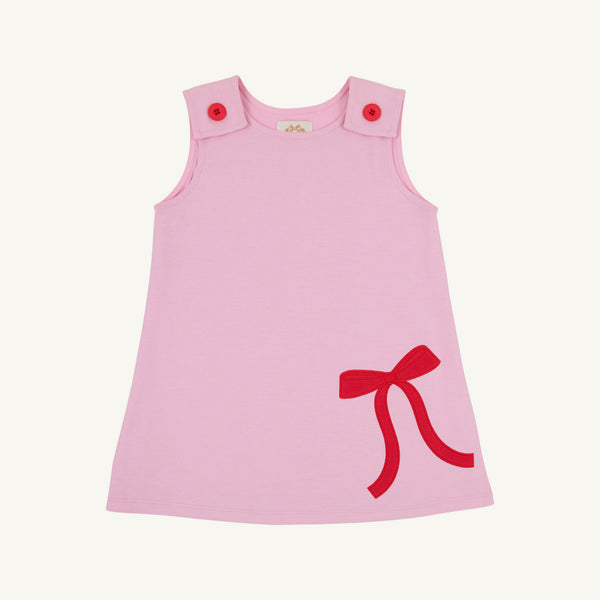 Introducing the Juliet Jumper - Pier Party Pink with Richmond Red Bow by The Beaufort Bonnet Company, a sleeveless toddler dress crafted from soft Pima Cotton Knit. This festive Christmas dress features two pink buttons on the shoulders and a charming Richmond Red bow on the lower right side.