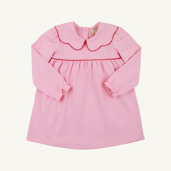 Introducing the Long Sleeve Maude’s Day Dress in Pier Party Pink with Richmond Red by The Beaufort Bonnet Company. Crafted from 100% Pima cotton, this classic baby dress features long sleeves, a red-trimmed scalloped collar, and gently gathered fabric at the chest. The simple design is finished with buttons at the back for easy dressing.