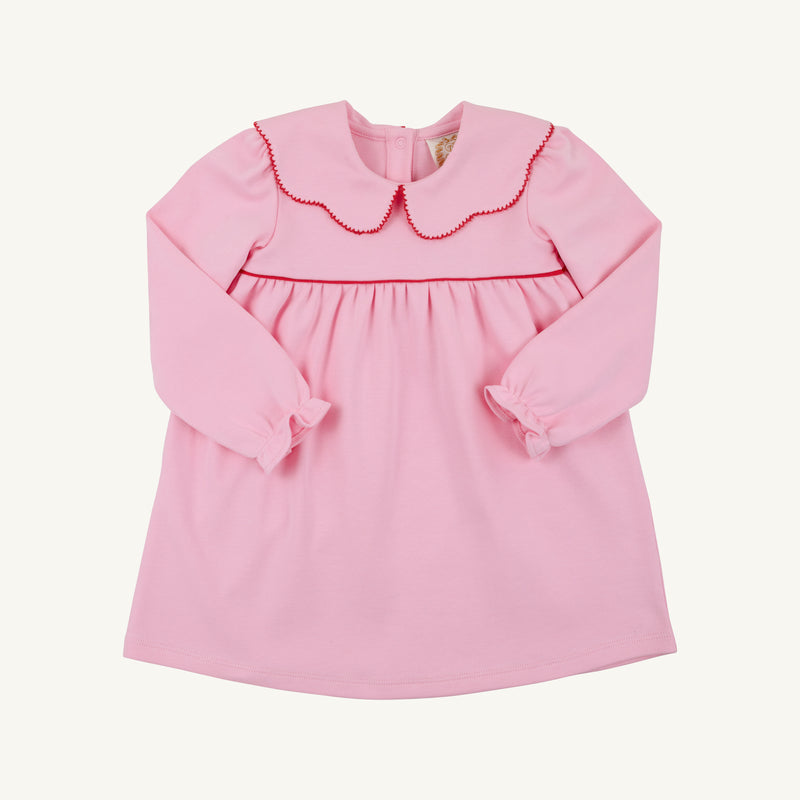 Introducing the Long Sleeve Maude’s Day Dress in Pier Party Pink with Richmond Red by The Beaufort Bonnet Company. Crafted from 100% Pima cotton, this classic baby dress features long sleeves, a red-trimmed scalloped collar, and gently gathered fabric at the chest. The simple design is finished with buttons at the back for easy dressing.