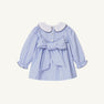 The Beaufort Bonnet Company Long Sleeve Dollie Mae Dress - Park City Periwinkle Ticking Stripe & Worth Avenue White features a white scalloped collar, back button closure, and a large fabric bow at the waist.