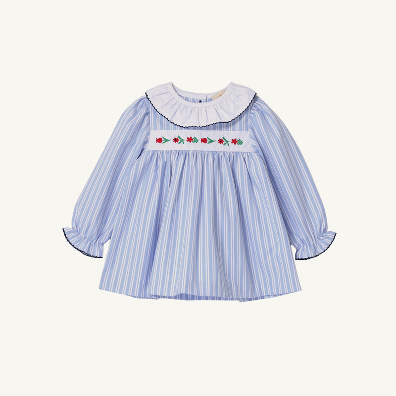 Long Sleeve Dollie Mae Dress in Park City Periwinkle Ticking Stripe & Worth Avenue White featuring a white ruffled collar, smocked bodice with floral embroidery, and dark scalloped trim on the collar and cuffs.