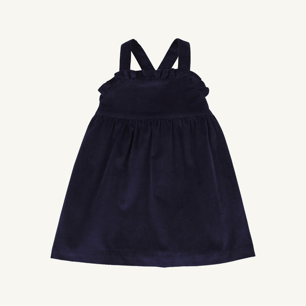 A child’s Macy Drew Dress in Nantucket Navy Corduroy by The Beaufort Bonnet Company, featuring a sleeveless design with ruffled detailing at the neckline and crossed back straps, shown on a plain white background. A perfect addition to any fall wardrobe.
