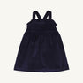 A child’s Macy Drew Dress in Nantucket Navy Corduroy by The Beaufort Bonnet Company, featuring a sleeveless design with ruffled detailing at the neckline and crossed back straps, shown on a plain white background. A perfect addition to any fall wardrobe.