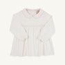 Maude’s A Line Top by The Beaufort Bonnet Company in Palmetto Pearl & Palm Beach Pink is a long-sleeve white baby top crafted from soft Pima cotton, featuring a Peter Pan collar with light pink trim on the collar and chest, gathered waist, back buttons, and elastic cuffs.