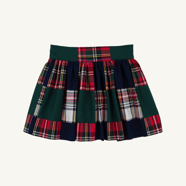 The McPrimm Party Skirt - Mercer Island Madras is a pleated mini skirt featuring a patchwork pattern of dark green, navy blue, and red and white plaid.