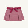 The Parson Pleated Skirt in Begley Berry Tweed by The Beaufort Bonnet Company features a pink textured pattern with elegant pleats and a coordinating pink waistband tied in a bow at the front. Shown against a plain white background, it’s the perfect fall skirt for girls.