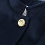 Detailed view of The Beaufort Bonnet Company’s Penelope Peacoat - Nantucket Navy for girls, highlighting the gold button adorned with a lion emblem near the collar and a glimpse of a white clothing tag beneath.
