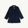 The Penelope Peacoat - Nantucket Navy by The Beaufort Bonnet Company is a girls’ peacoat with long sleeves, a single gold button at the collar, and a flared skirt. This simple and elegant design is displayed on a plain white background.