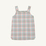 The Beaufort Bonnet Company’s Pleated Ginny Jumper in Manalapan Plaid, a sleeveless dress with thick shoulder straps featuring a pastel pink, green, blue, and white plaid pattern, is displayed laid flat on a plain background.