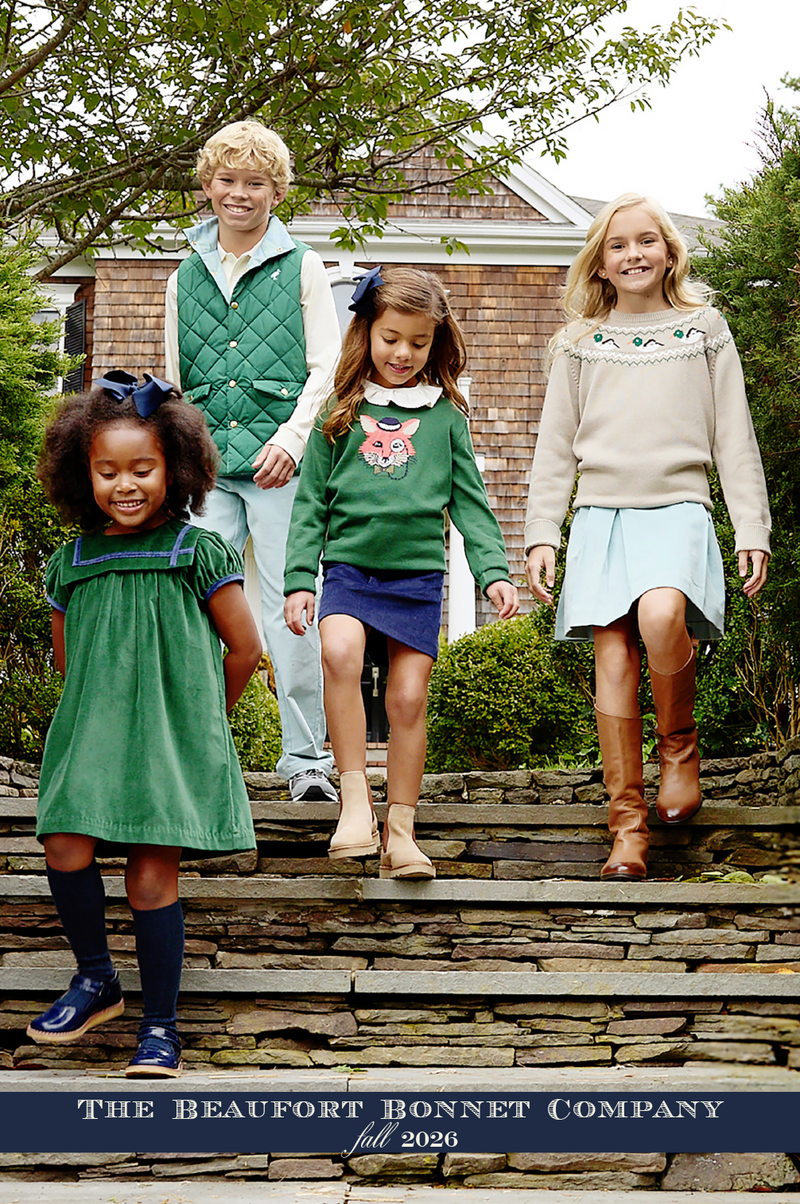 Four smiling children dressed in fall outfits walk down stone steps outdoors, surrounded by greenery and a house in the background. “The Beaufort Bonnet Company Fall 2026 Catalog” is featured at the bottom of the image, showcasing timeless style for little ones.